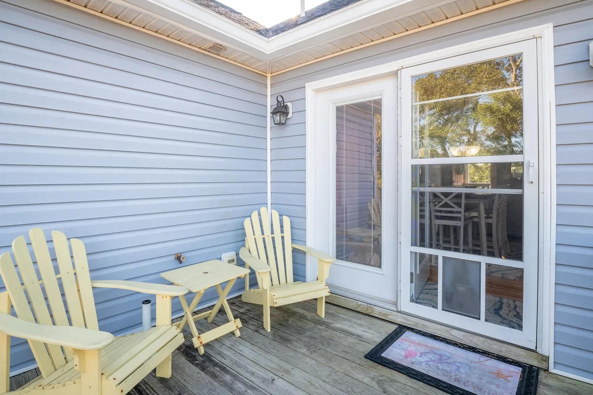 This inviting exterior porch features bright yellow Adirondack chairs and a wooden table, hinting at relaxed moments spent outdoors. Light fills the space, suggesting a transition between indoor comfort and outdoor adventure.